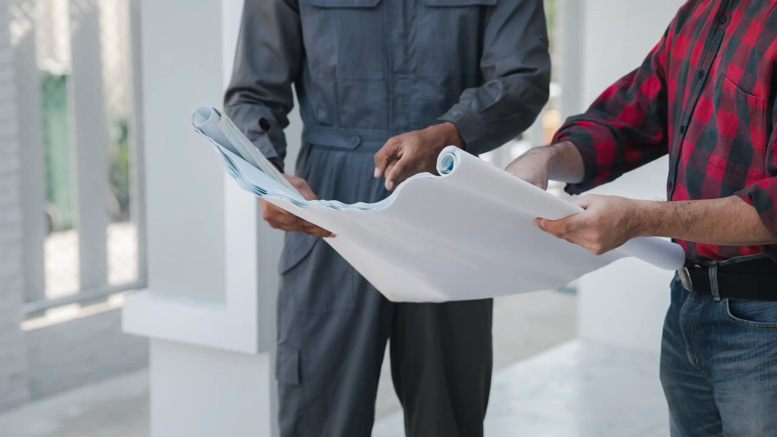 Two contractors examining house blueprints for Structural Assessments