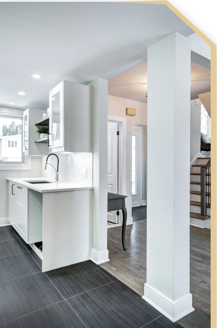 Open-plan modern kitchen area with white cabinets, tile backsplash, integrated sink and dark floor tiles showcasing Kitchen Remodeling