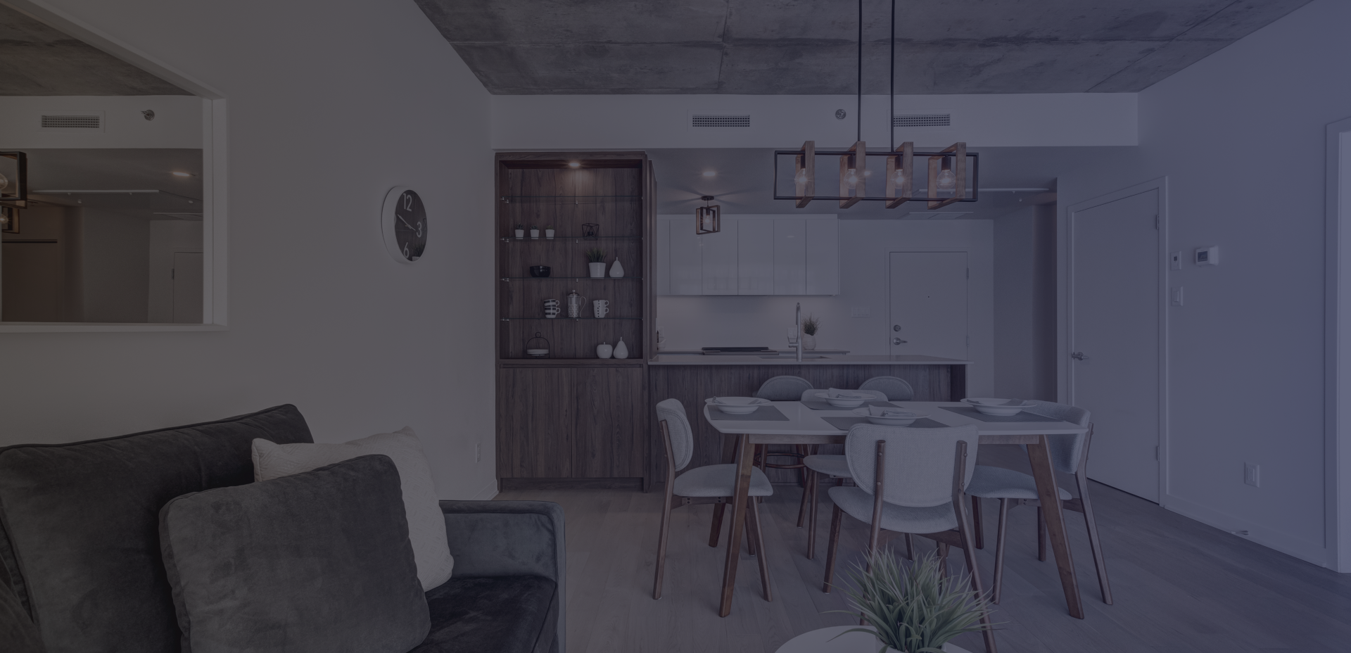 Open-plan living room with custom kitchen renovation featuring white cabinets, island, dining table and hardwood floors