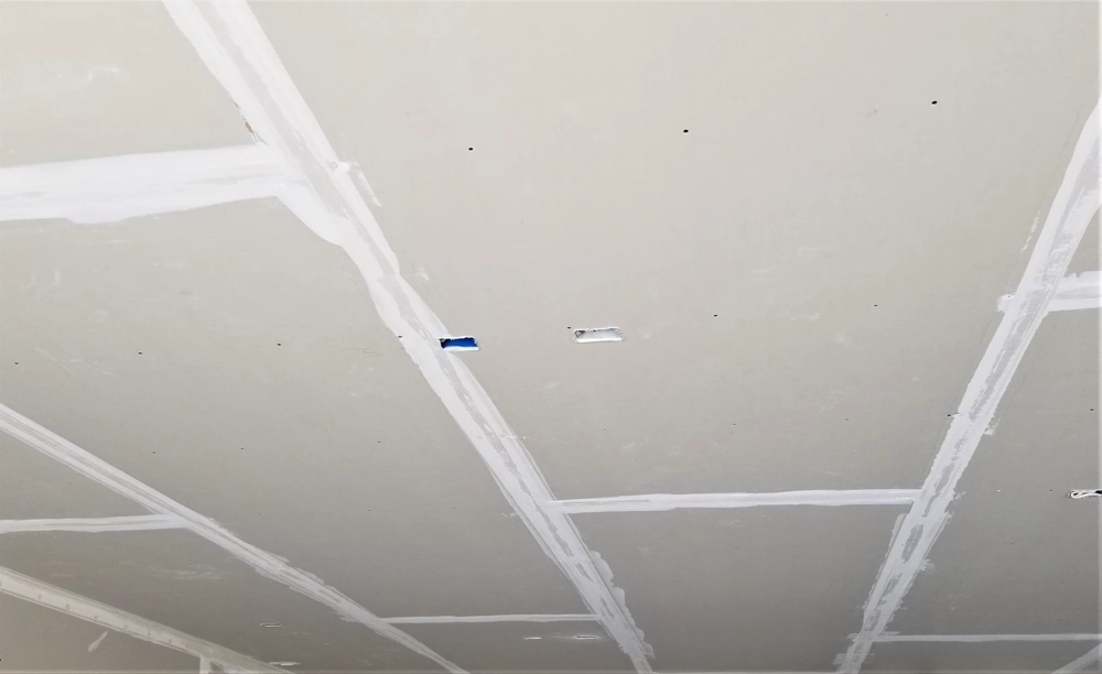 Interior ceiling with Drywall installation showing taped and mudded seams