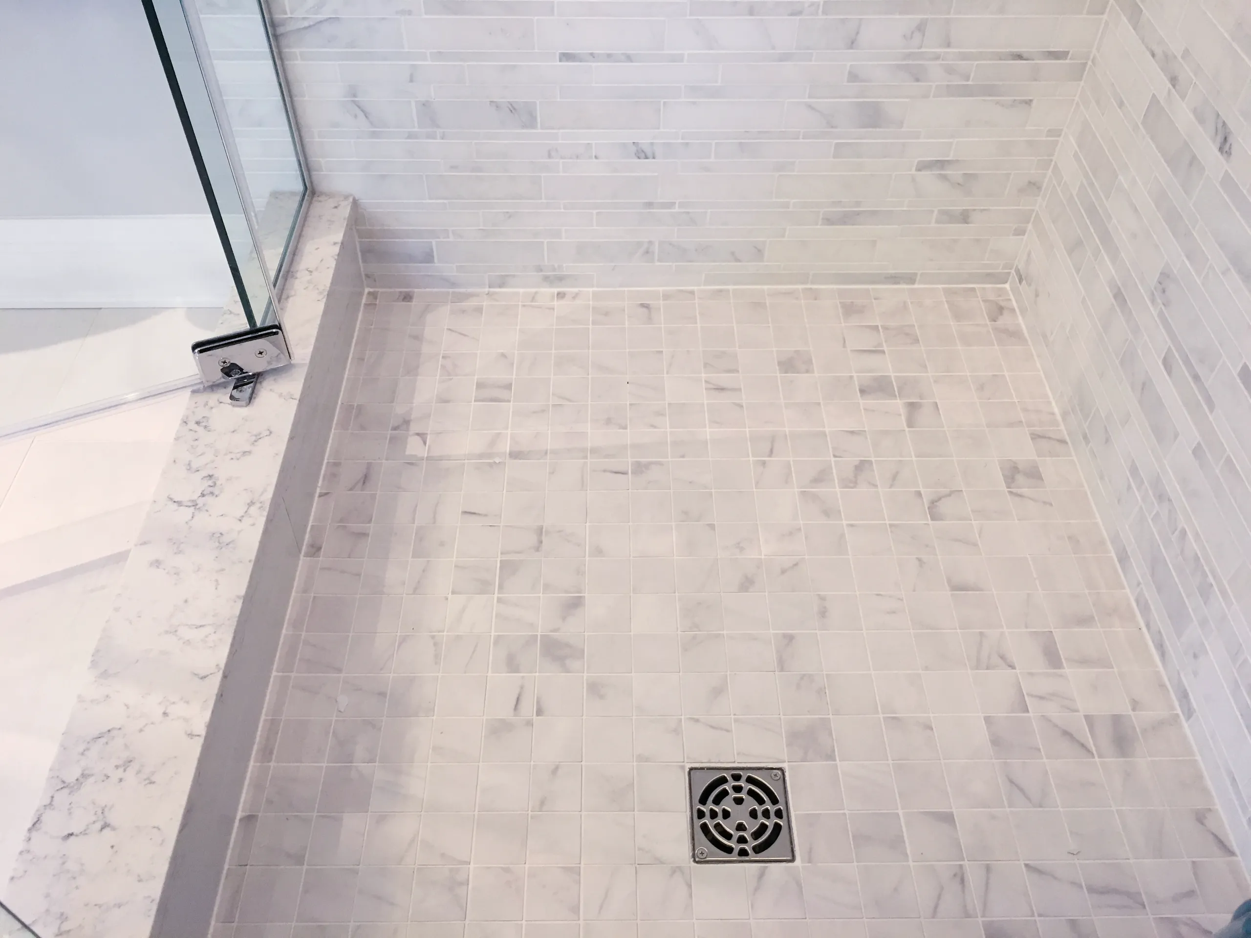 Marble mosaic tiled shower floor with square drain and glass shower door threshold, Tile Setting