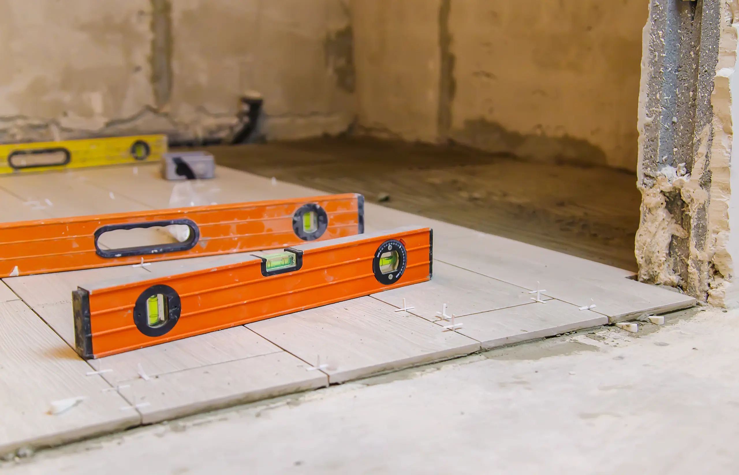Spirit levels on freshly laid floor tiles with spacers for Tile Setting