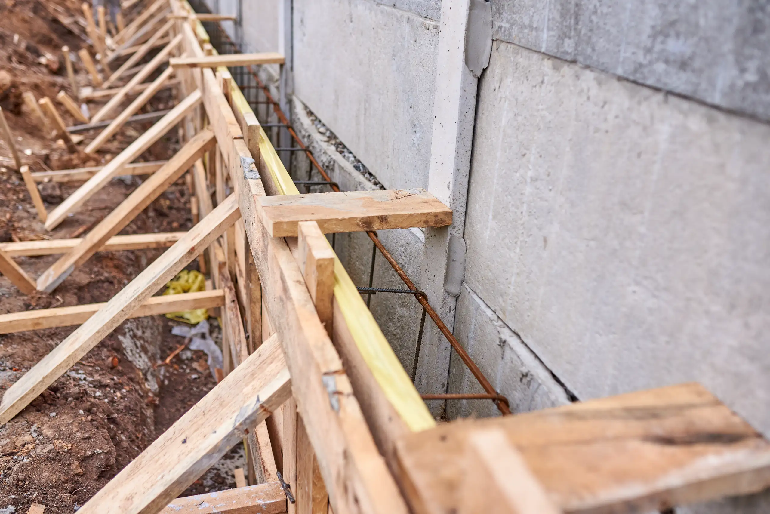 Wooden concrete formwork with steel rebar attached to foundation wall Structural Framing